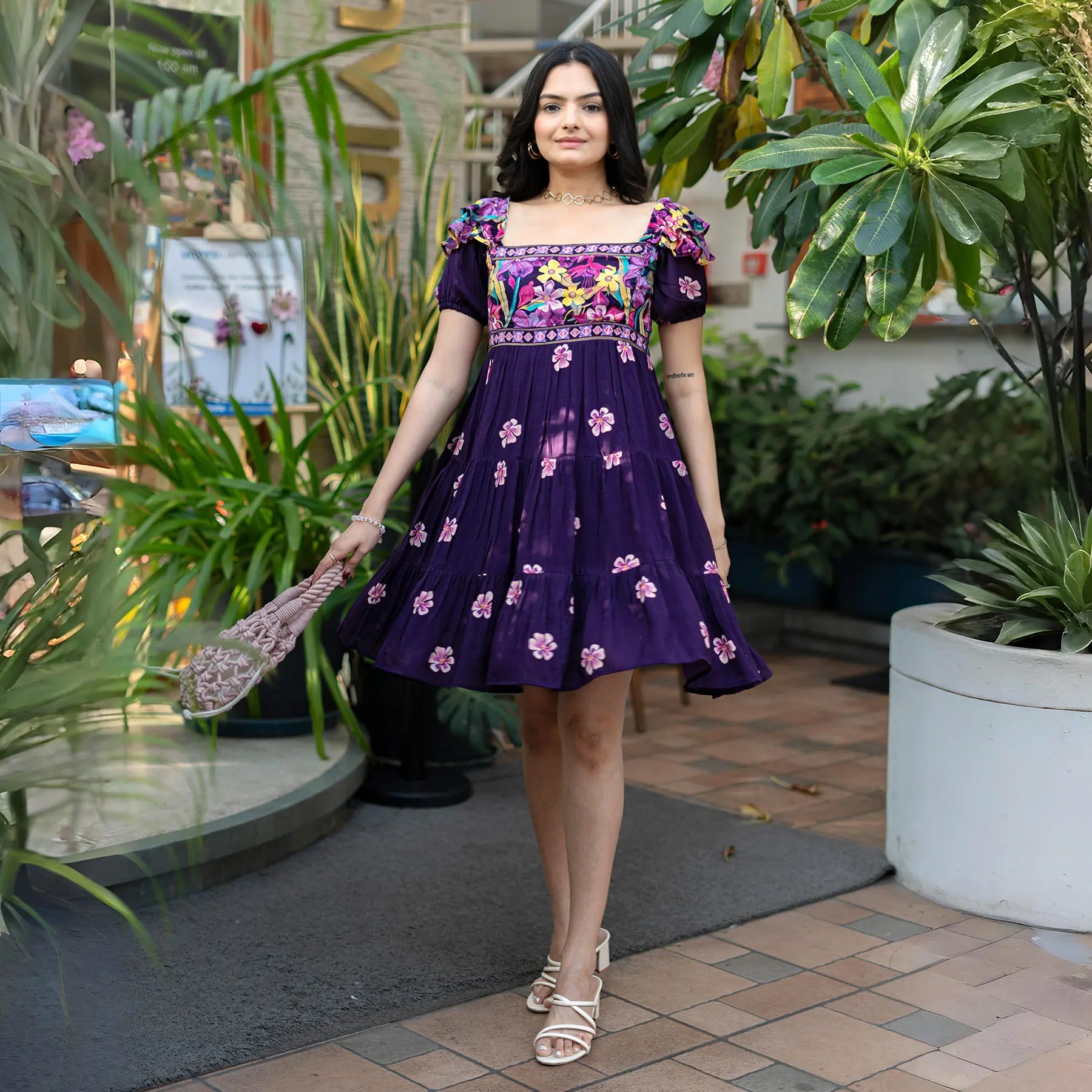 Front walking pose in a floral embroidered knee length one piece dress with puff sleeves