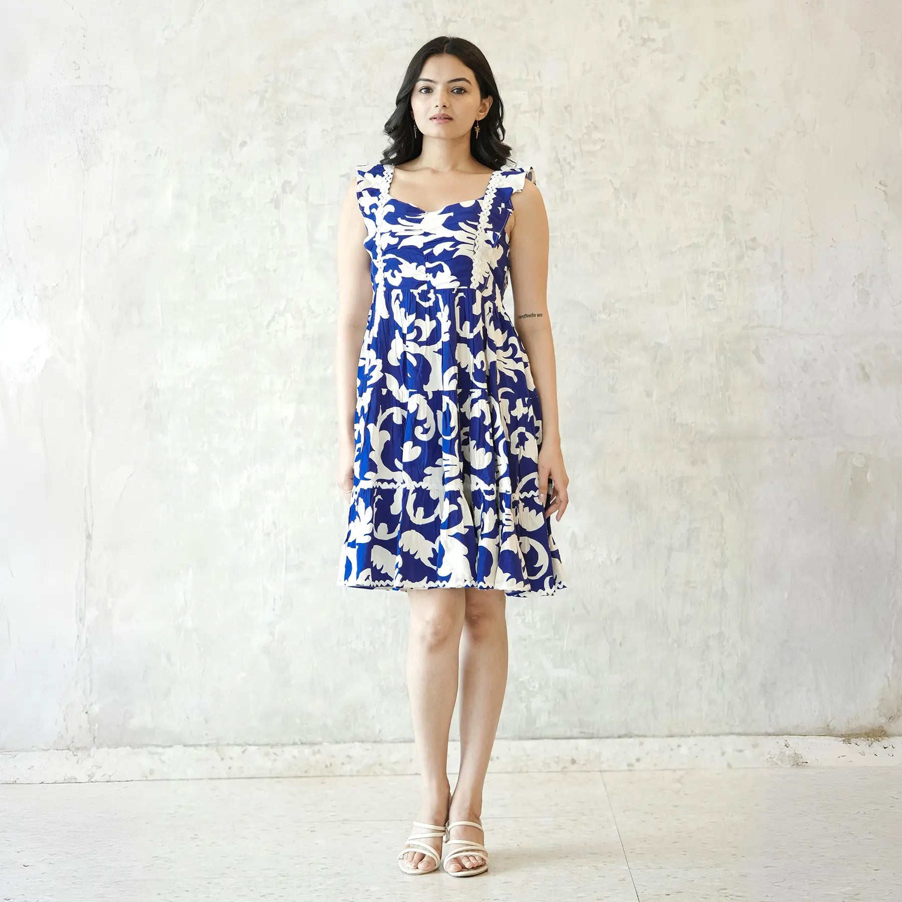 Woman wearing blue sleeveless short dress for brunch or summer outings.