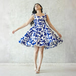 Playful twirl pose in a sleeveless one piece dress, short summer dress ideal for beach outings and casual gatherings