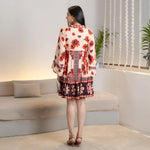Model in back pose dressed in a floral frocks for women design, showing the natural flow and tiered flare of the dress