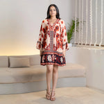 Model in a floral frock style one piece with long sleeves, posing front to showcase the tiered flare