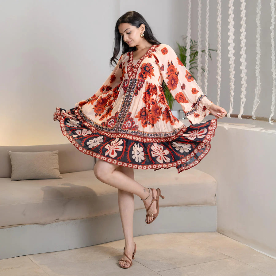 Model in side profile wearing a full sleeve one piece dress with bold floral print and flared silhouette