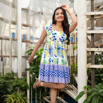 Front view smiling pose in a colorful short summer dress with playful print and lightweight fabric
