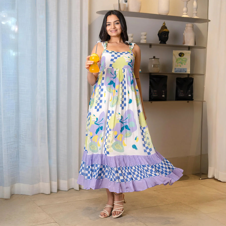 Smiling in a sleeveless Tropical Breeze viscose maxi dress for women, holding a drink – perfect for resort wear or brunch outings