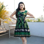 Front pose of a green one piece dress, sleeveless short frock style with tropical leaf print.