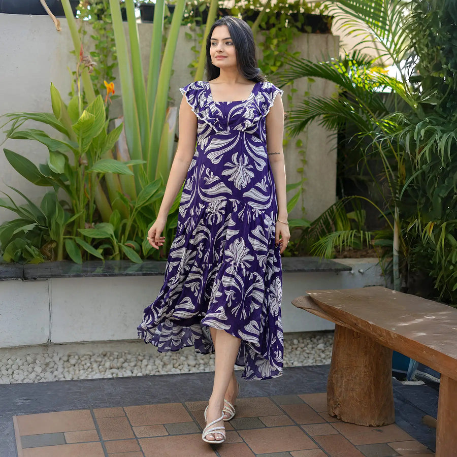 Woman wearing sleeveless one-piece maxi dress with floral print, captured in side view.