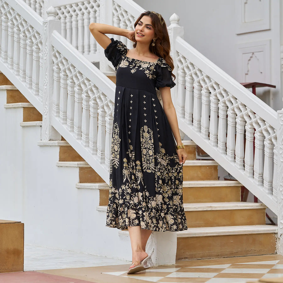 Black midi dress flowing as woman twirls gracefully beside a staircase