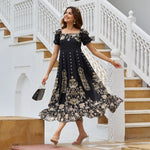 Woman joyfully twirling in a stylish black floral midi dress with flared hem