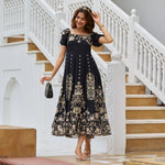 Woman walking outdoors in a black A-line midi dress with gold floral print and puff sleeves